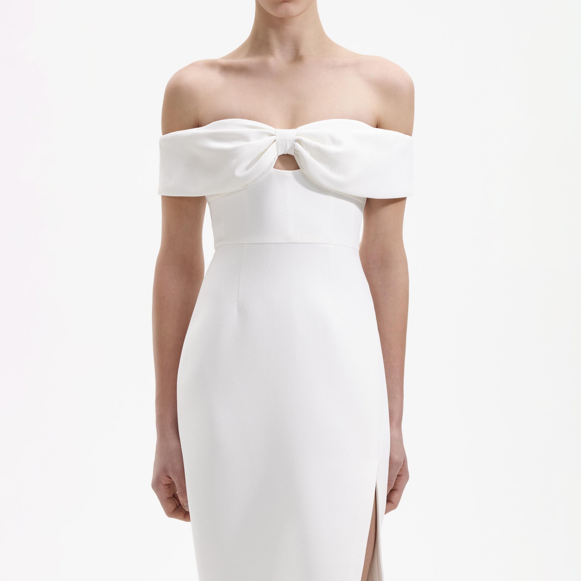 A close up of a woman wearing the White Crepe Bow Off Shoulder Midi Dress