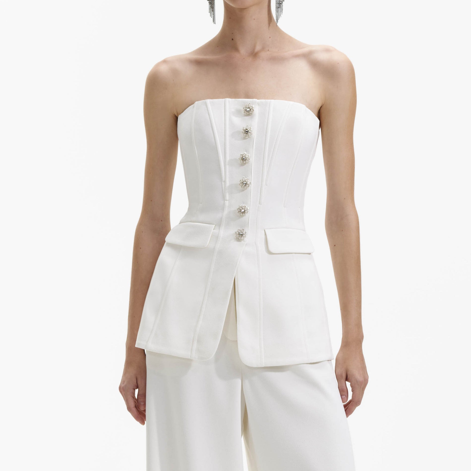 A close up of a woman wearing the White Bandeau Crepe Jumpsuit