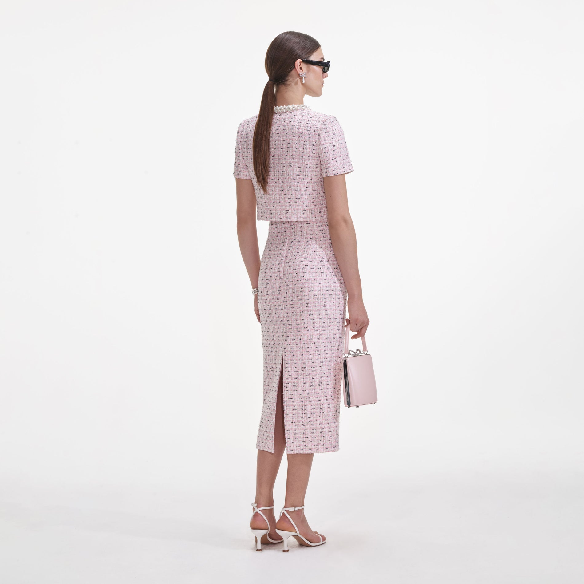 Back view of a woman wearing the Pink Boucle Pearl Midi Skirt