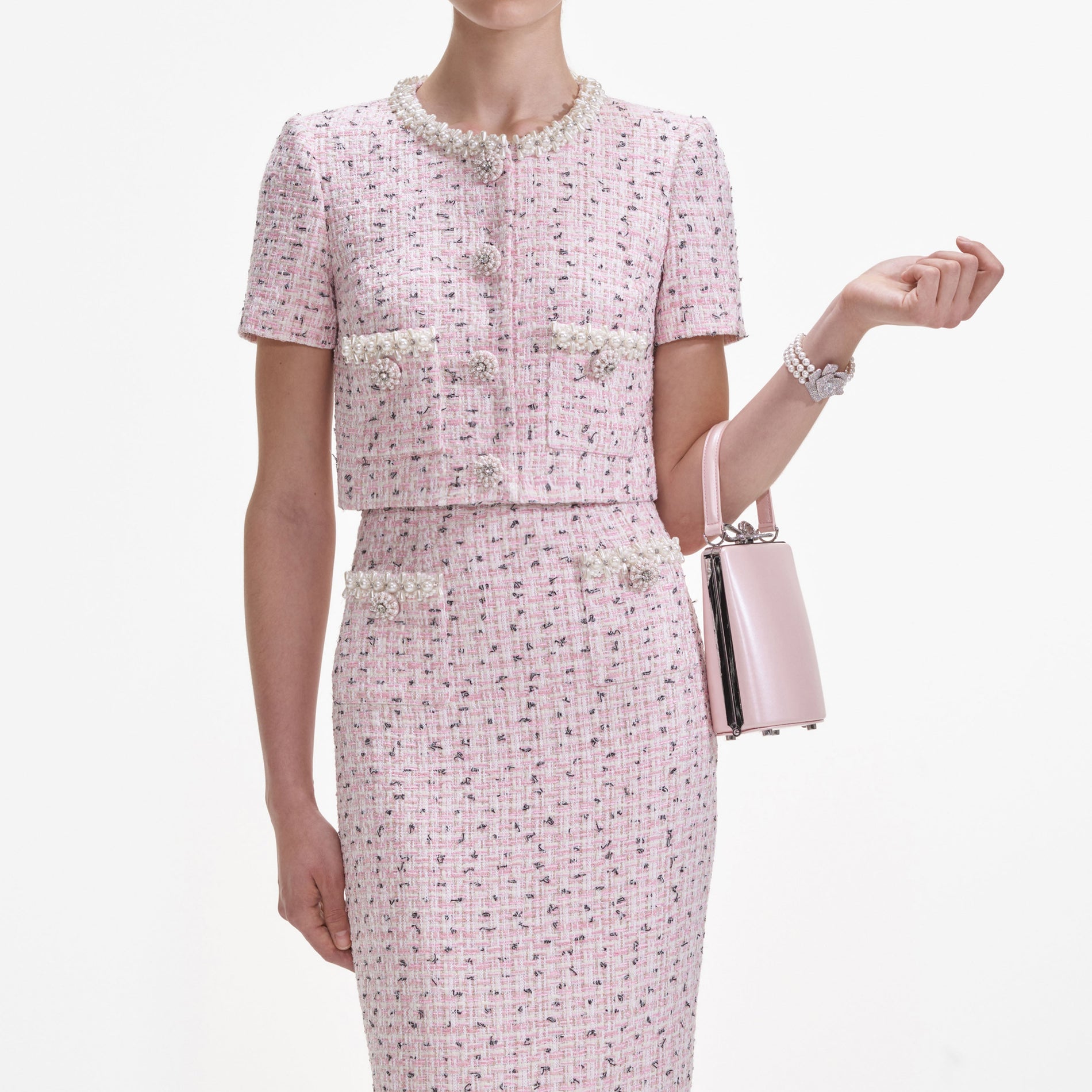 A close up of a woman wearing the Pink Boucle Pearl Midi Skirt
