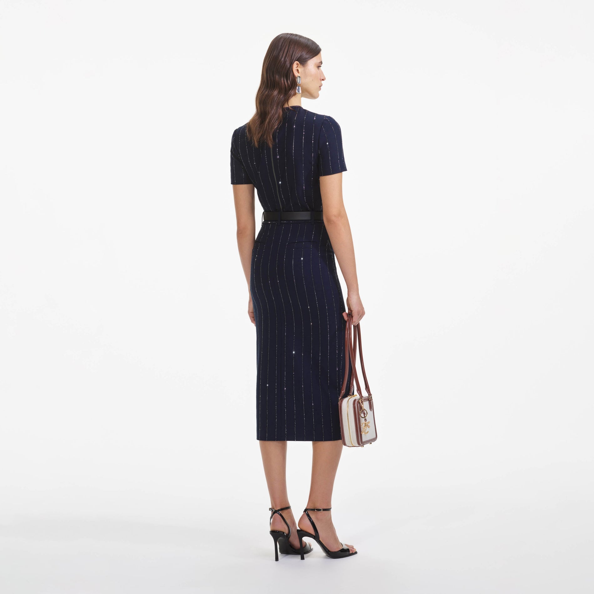 Back view of a woman wearing the Navy Rhinestone Pinstripe Midi Skirt