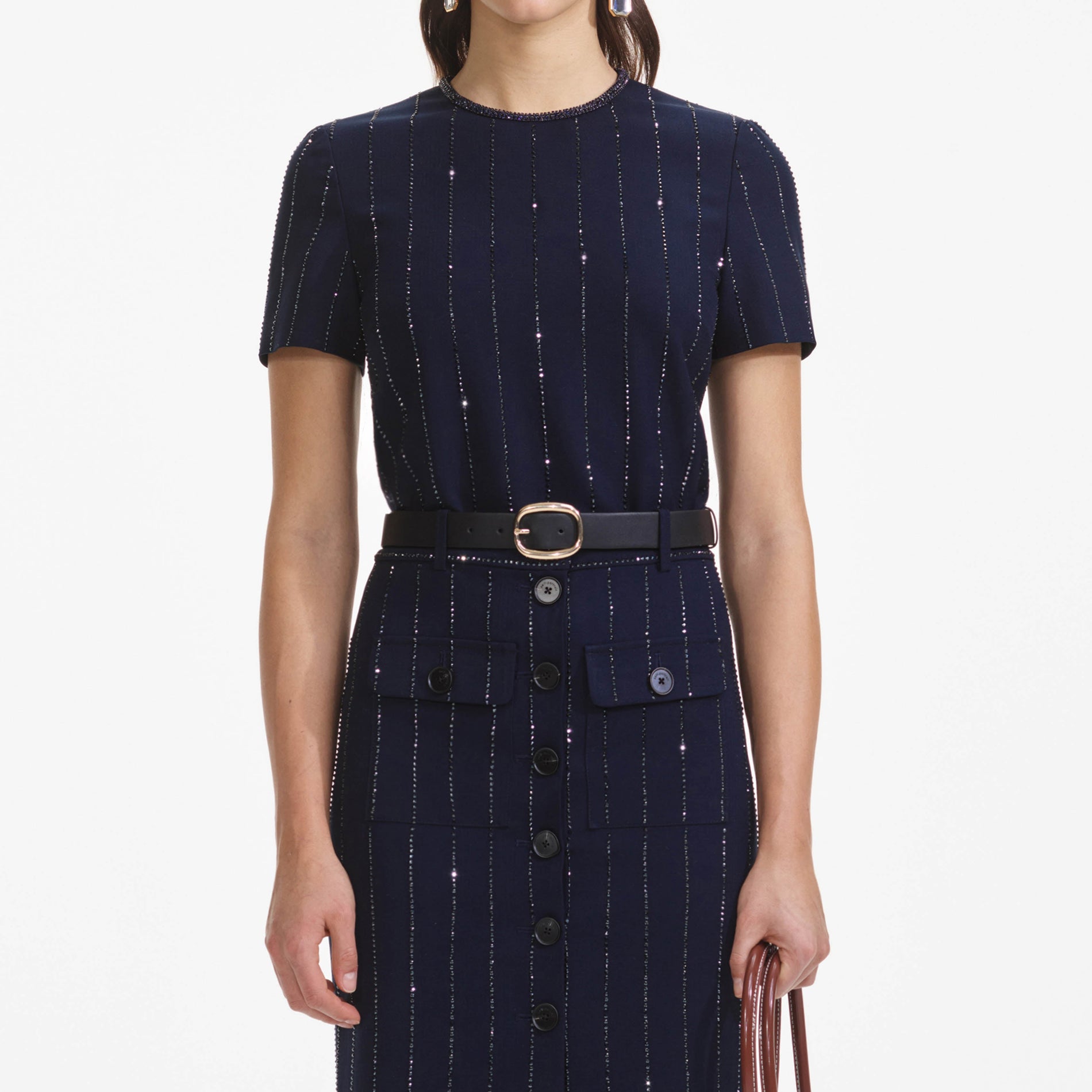 A close up of a woman wearing the Navy Rhinestone Pinstripe Midi Skirt