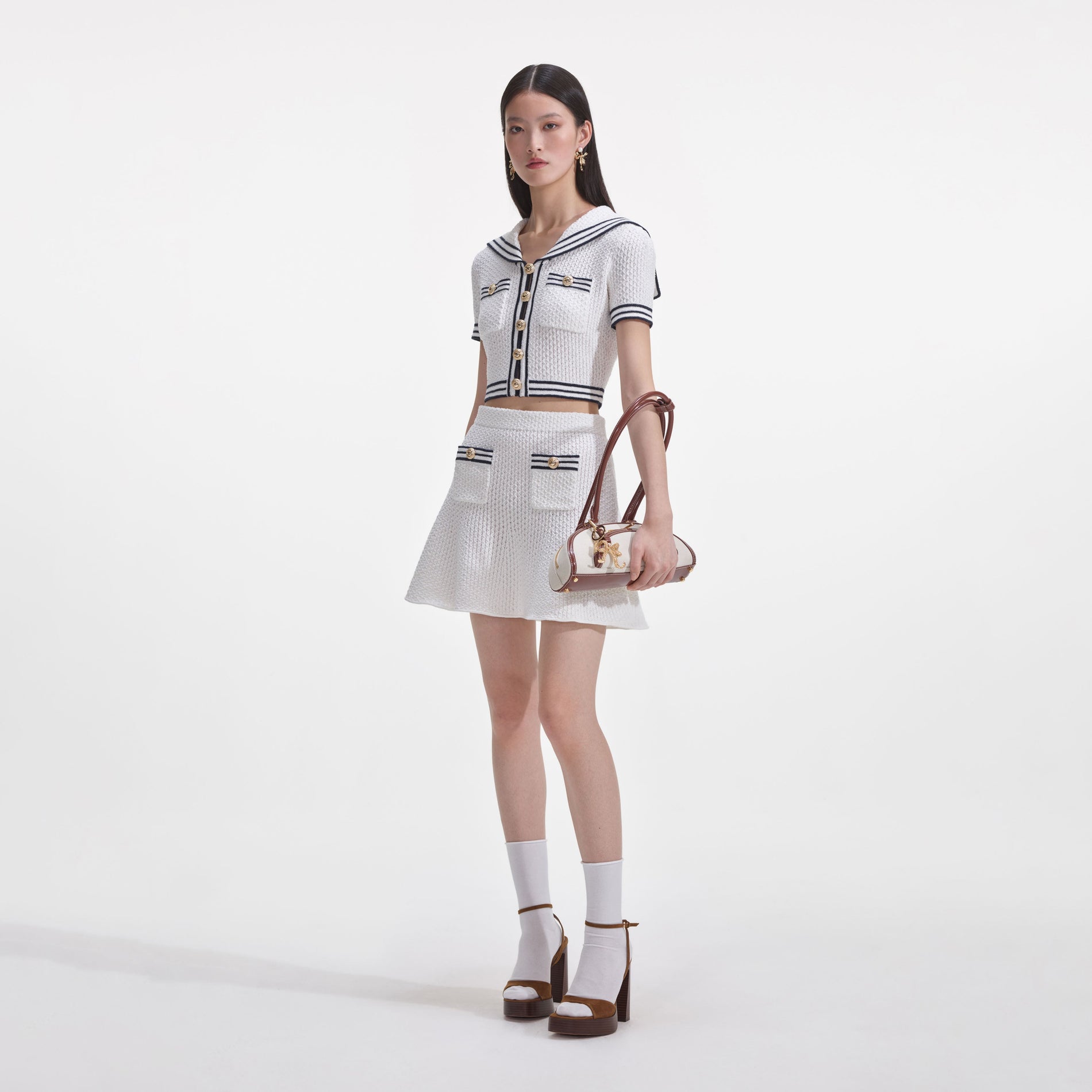 Side view of a woman wearing the White Textured Knit Mini Skirt