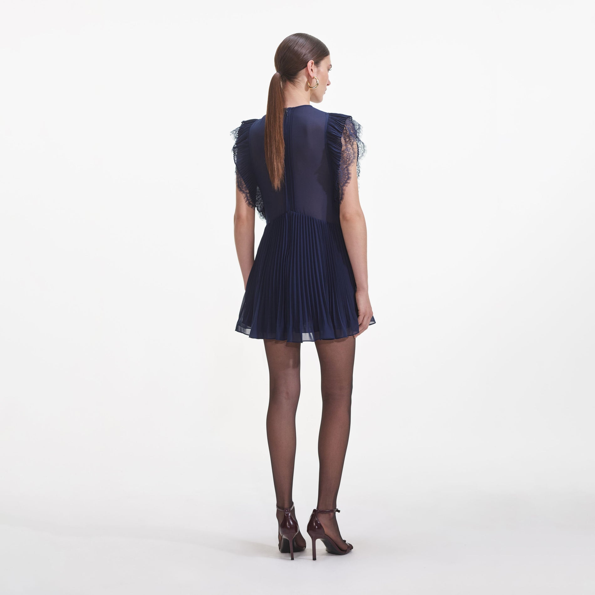 Back view of a woman wearing the Navy Chiffon Ruffle Mini Dress