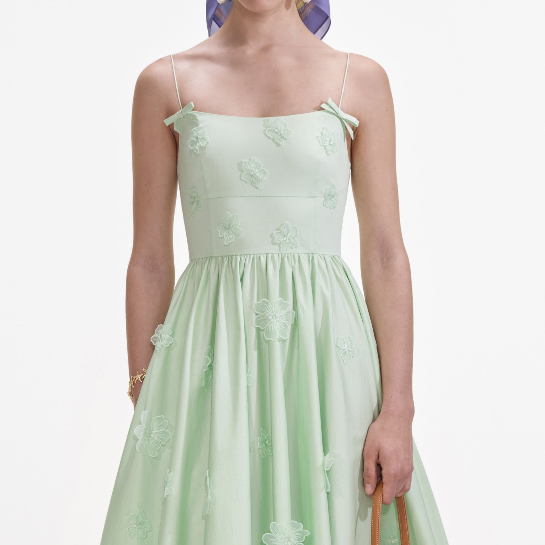 A close up of a woman wearing the Green Cotton Flower Midi Dress