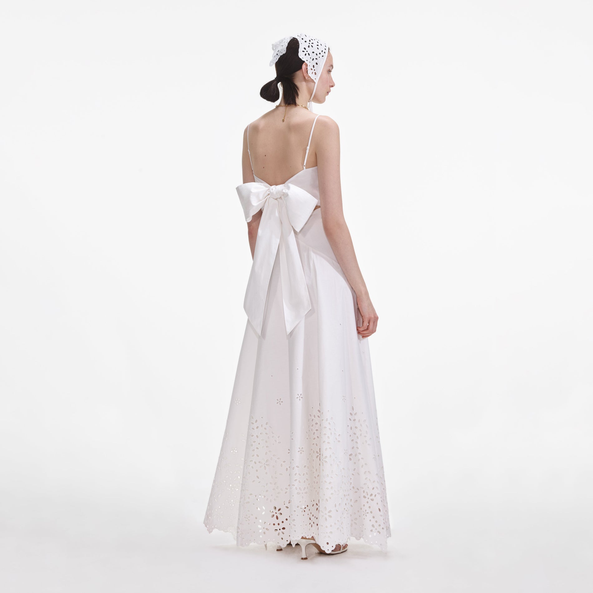 Back view of a woman wearing the White Cotton Embroidered Maxi Dress