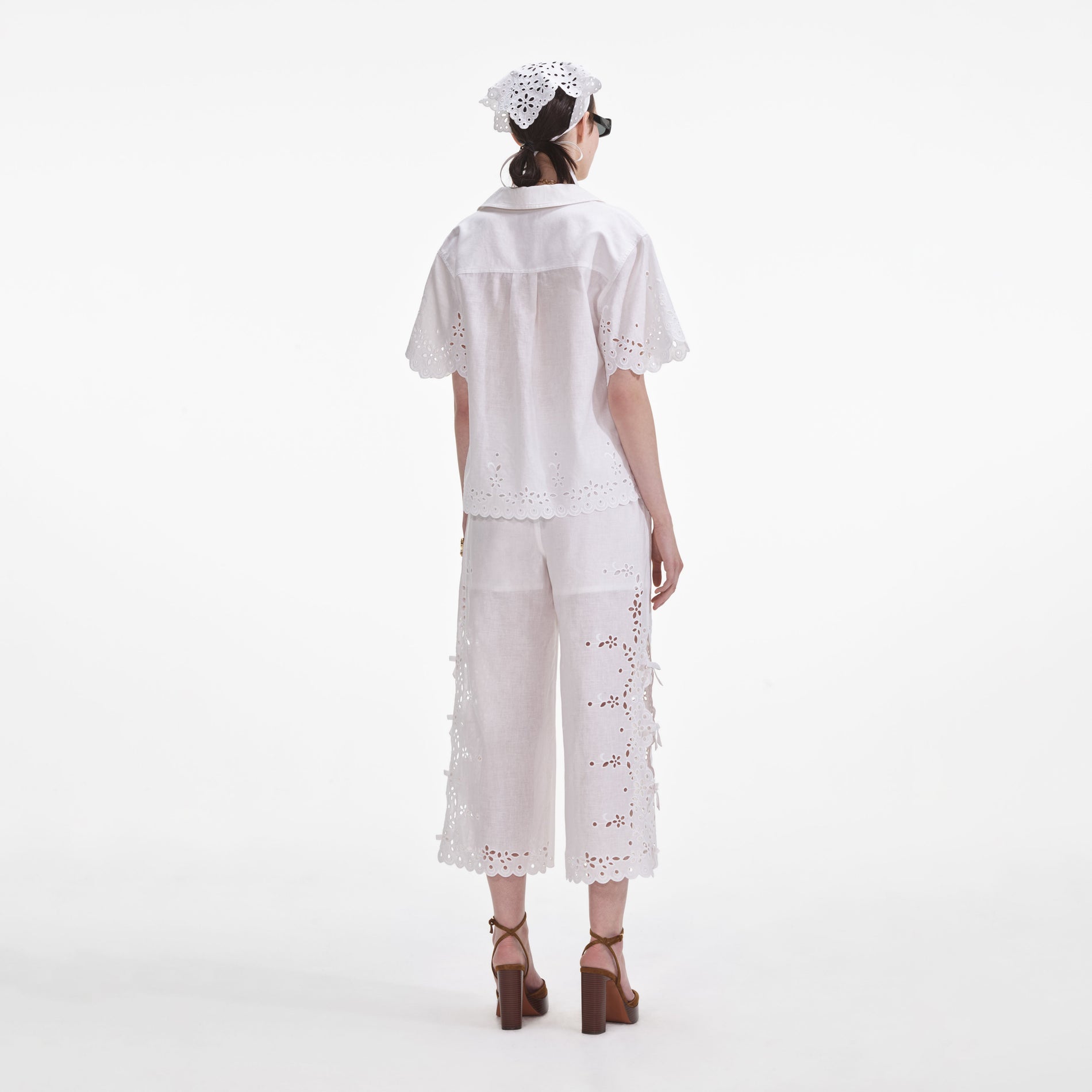 Back view of a woman wearing the Cream Linen Embroidered Trousers