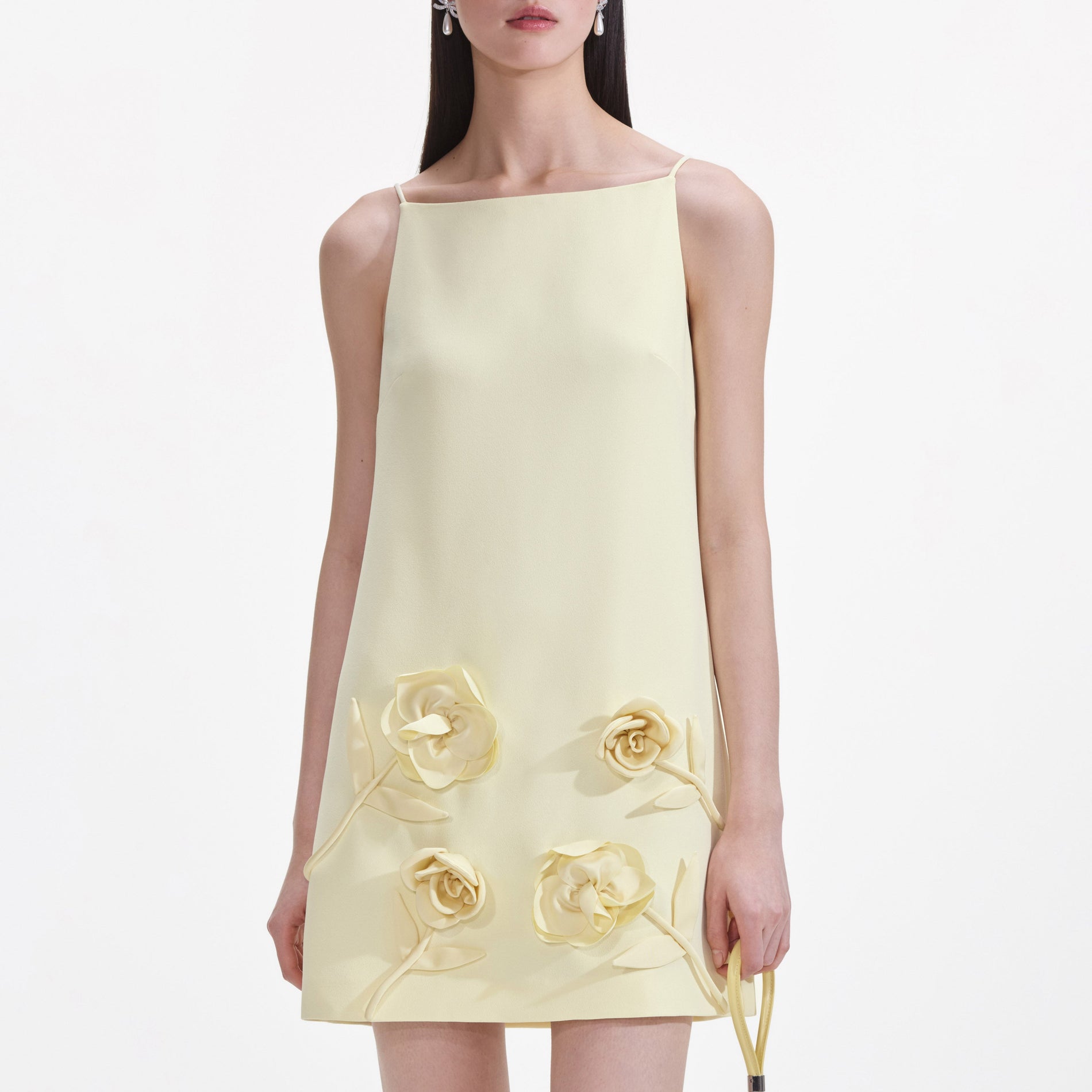 A close up of a woman wearing the Yellow Crepe Flower Mini Dress