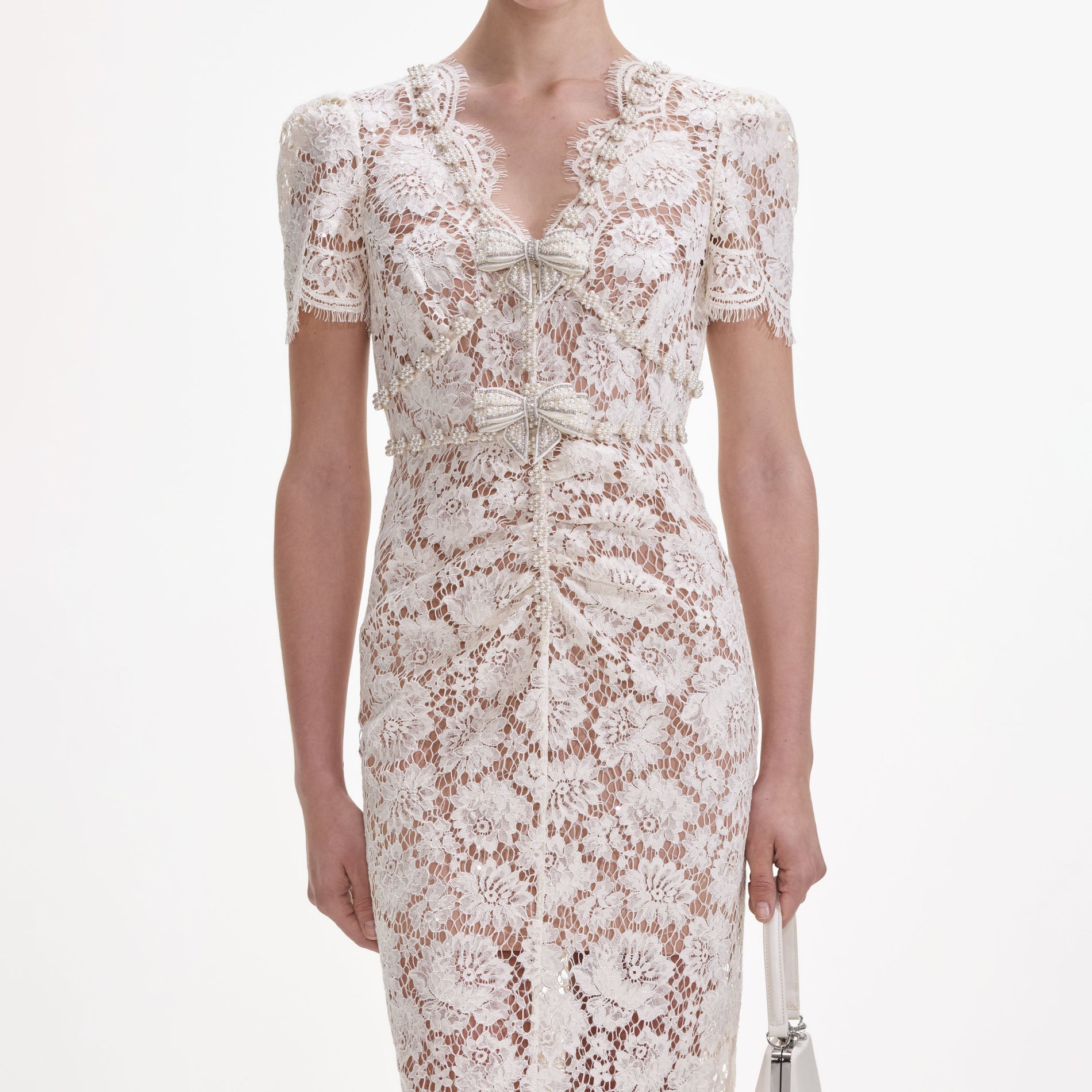 A close up of a woman wearing the Cream Fine Lace Pearl Midi Dress