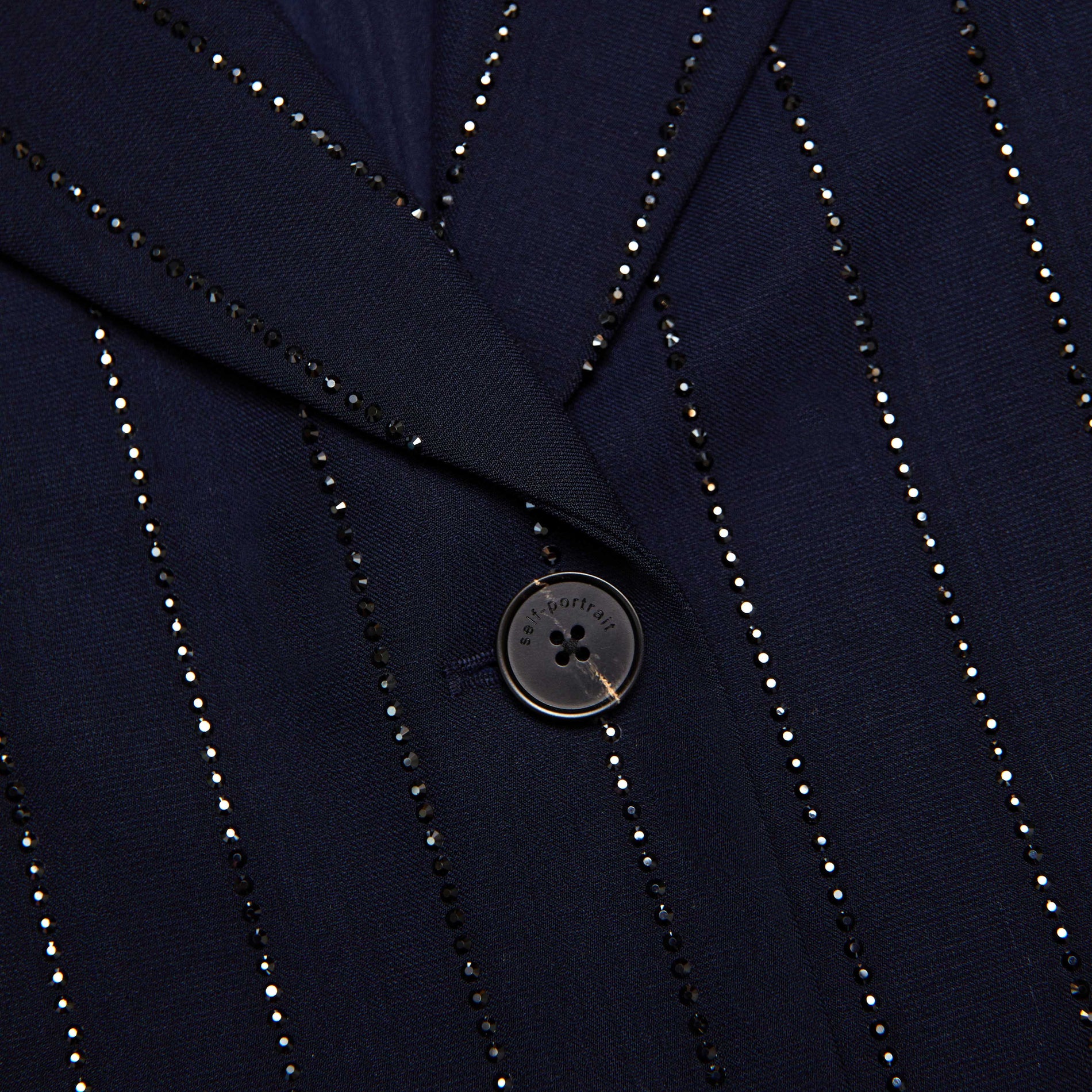 Side view of a woman wearing the Navy Rhinestone Pinstripe Blazer
