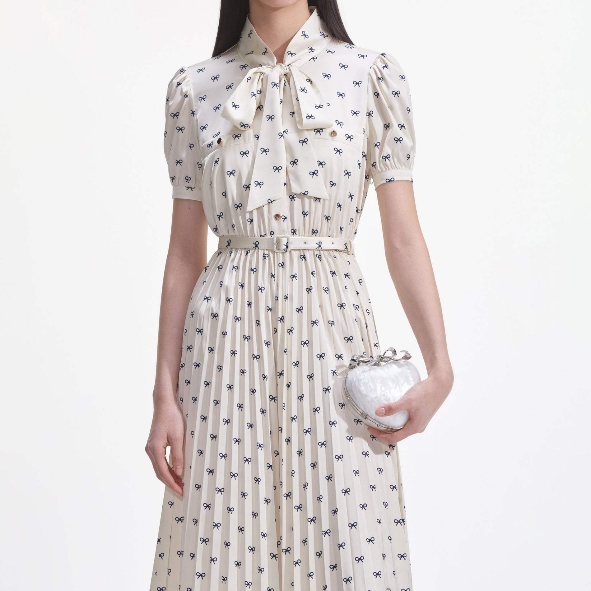 A close up of a woman wearing the Cream Satin Bow Print Midi Dress
