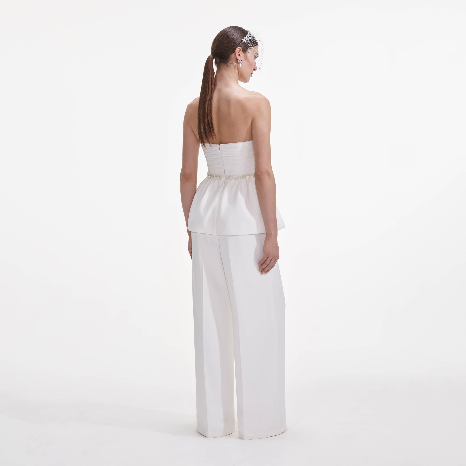 Back view of a woman wearing the White Organza Bow Jumpsuit