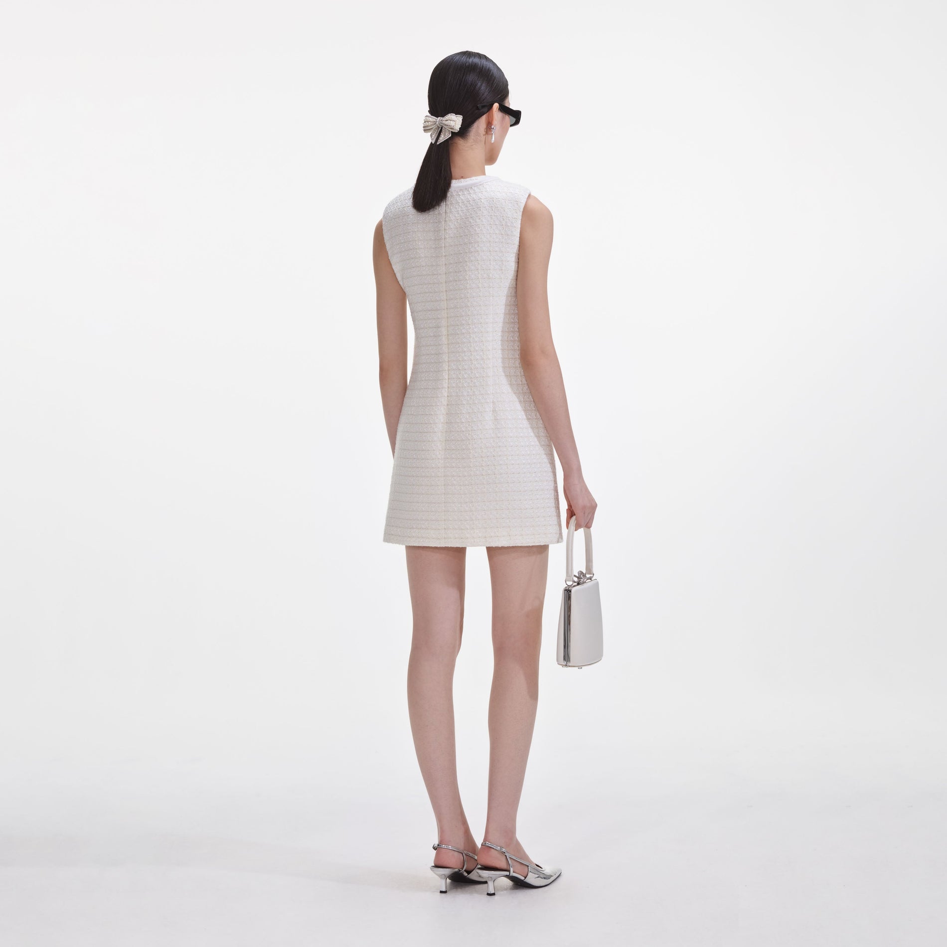 Back view of a woman wearing the Cream Boucle Bow Mini Dress