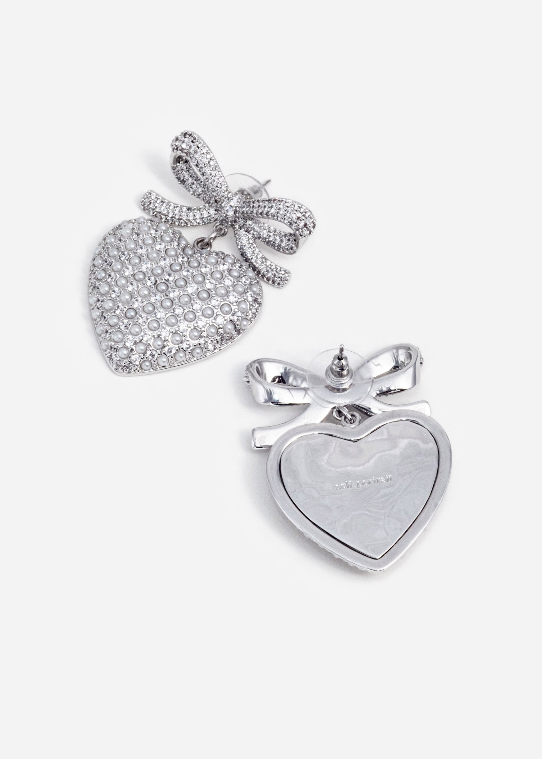 A photo of the Crystal Bow Pearl Heart Earrings