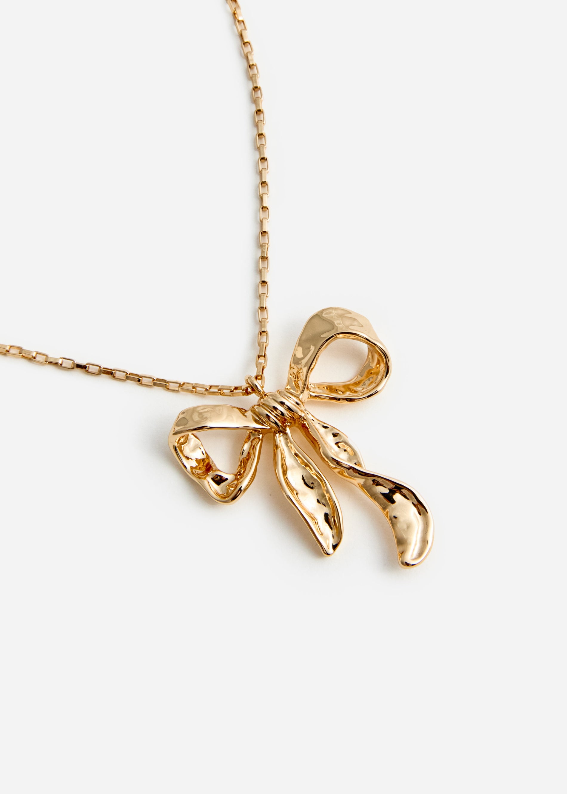 A photo of the Mottled Gold Bow Pendant Necklace