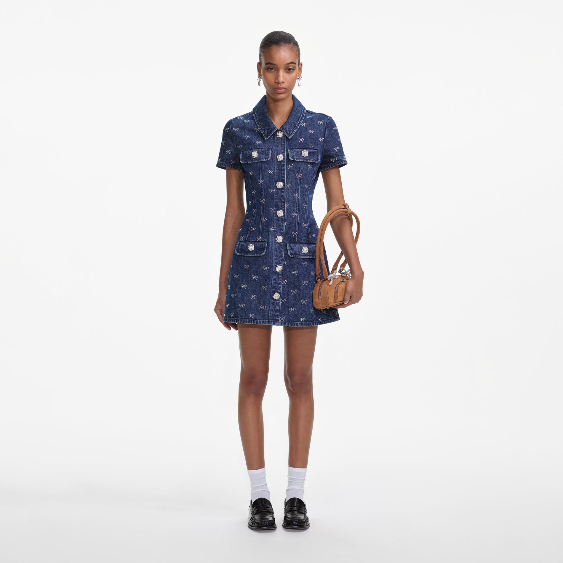 A close up of a woman wearing the Denim Diamante Bow Collared Mini Dress