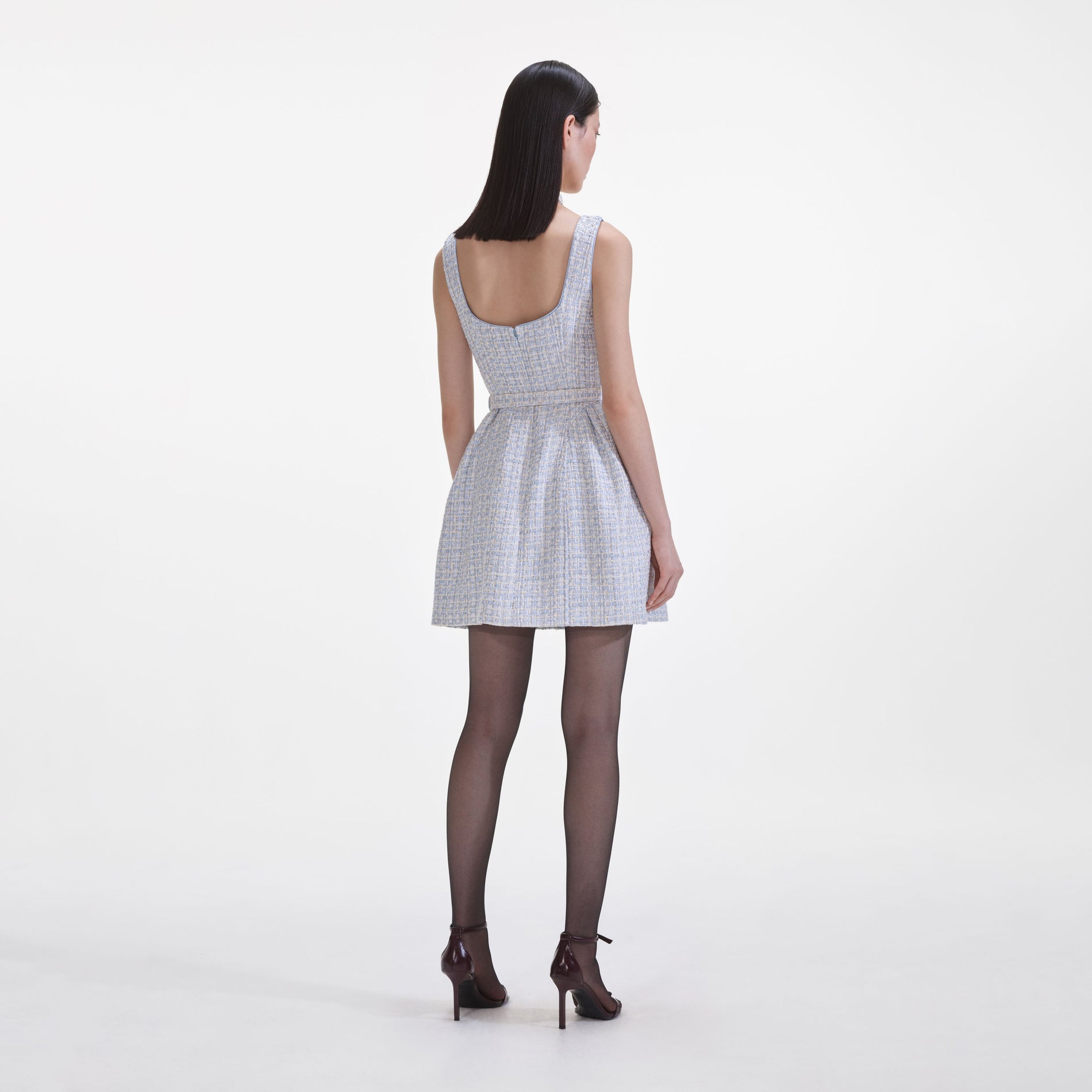 Back view of a woman wearing the Blue Boucle Sleeveless Mini Dress