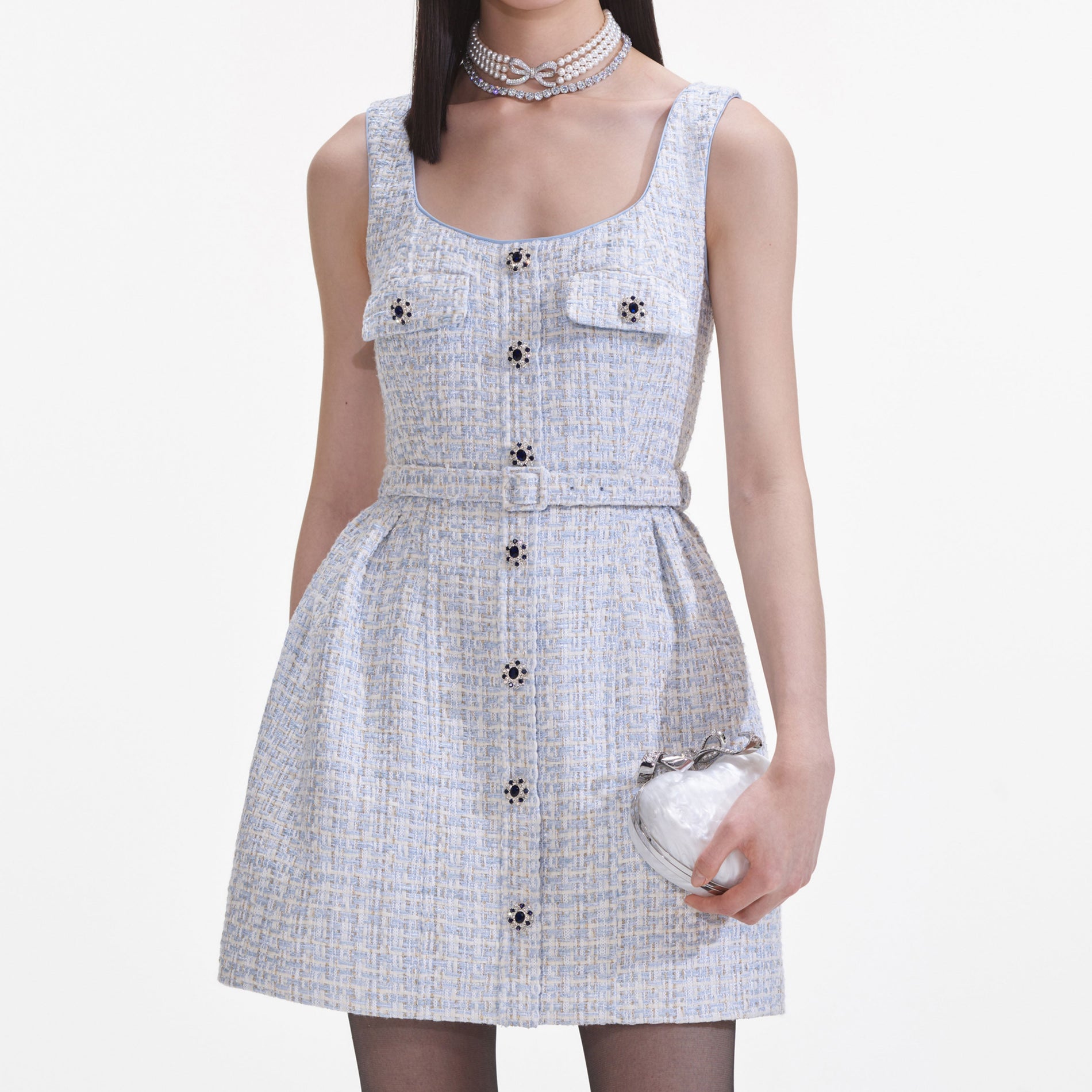 A close up of a woman wearing the Blue Boucle Sleeveless Mini Dress