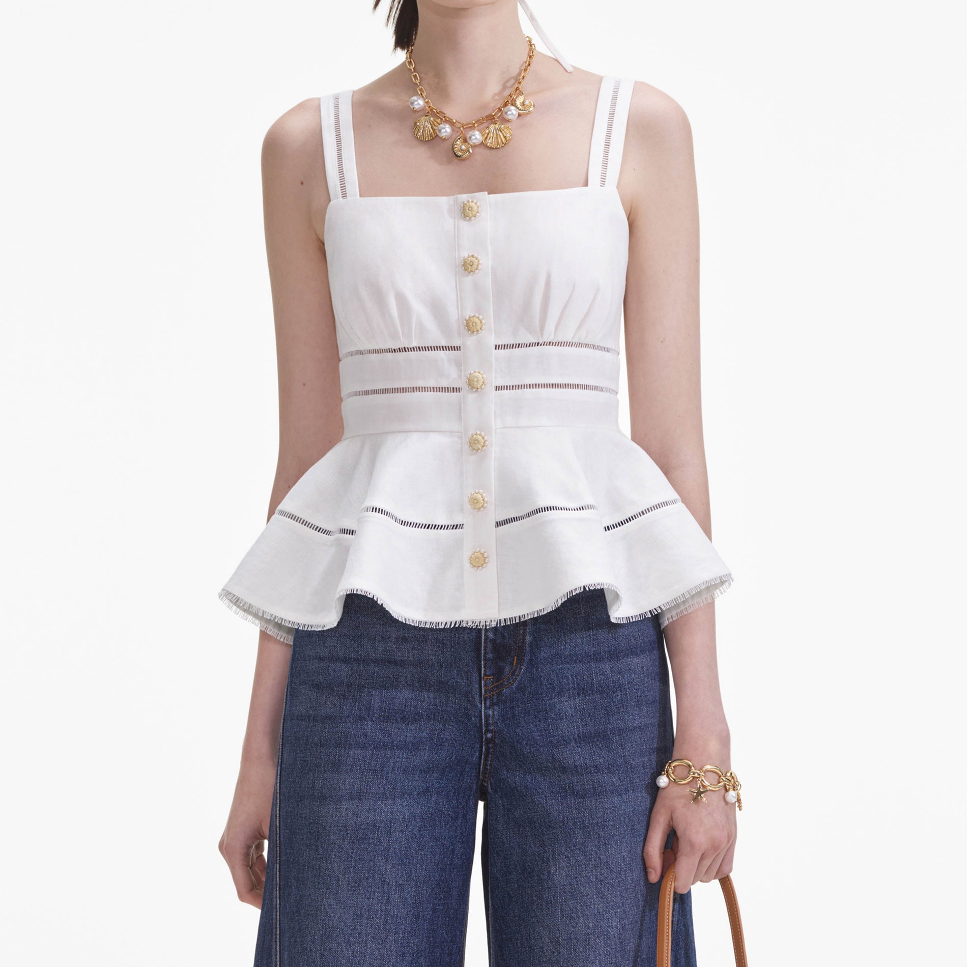 A close up of a woman wearing the White Linen Peplum Top