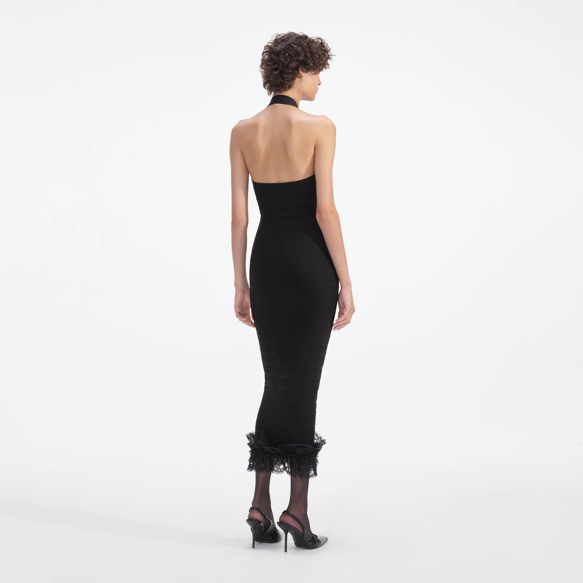 Back view of a woman wearing the Black Knit Zip Ruffle Midi Dress