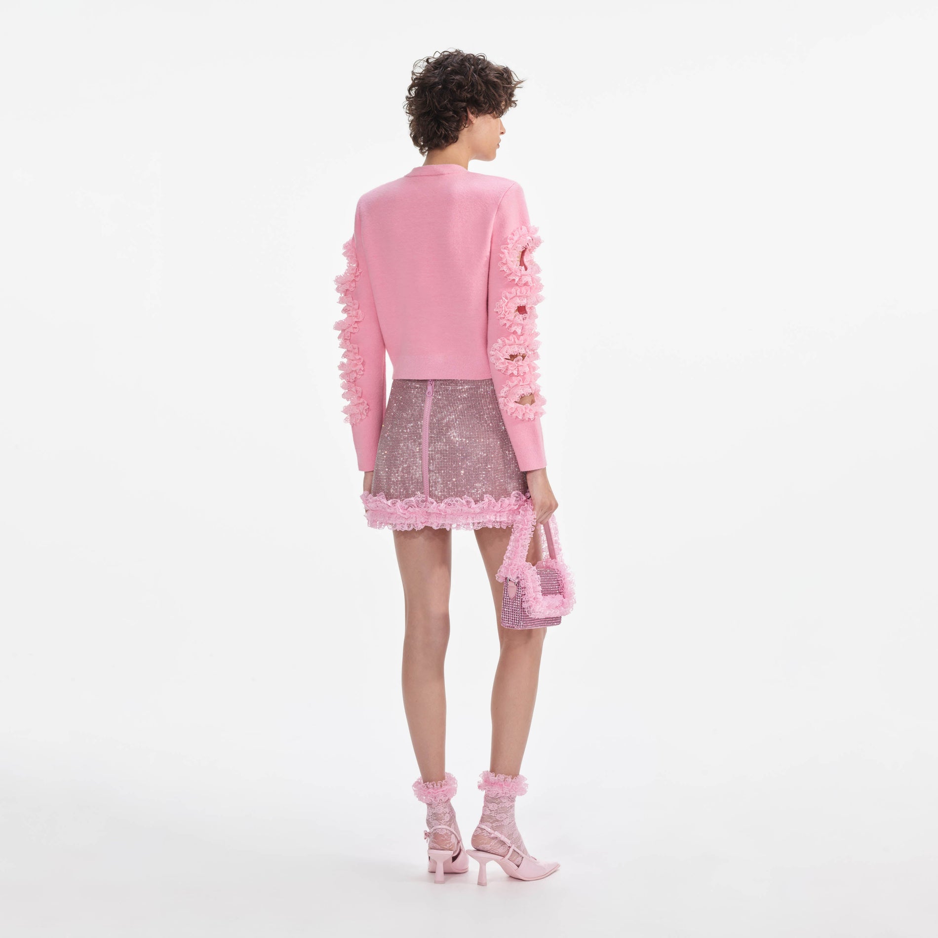 Back view of a woman wearing the Pink Crystal Chainmail Mini Skirt