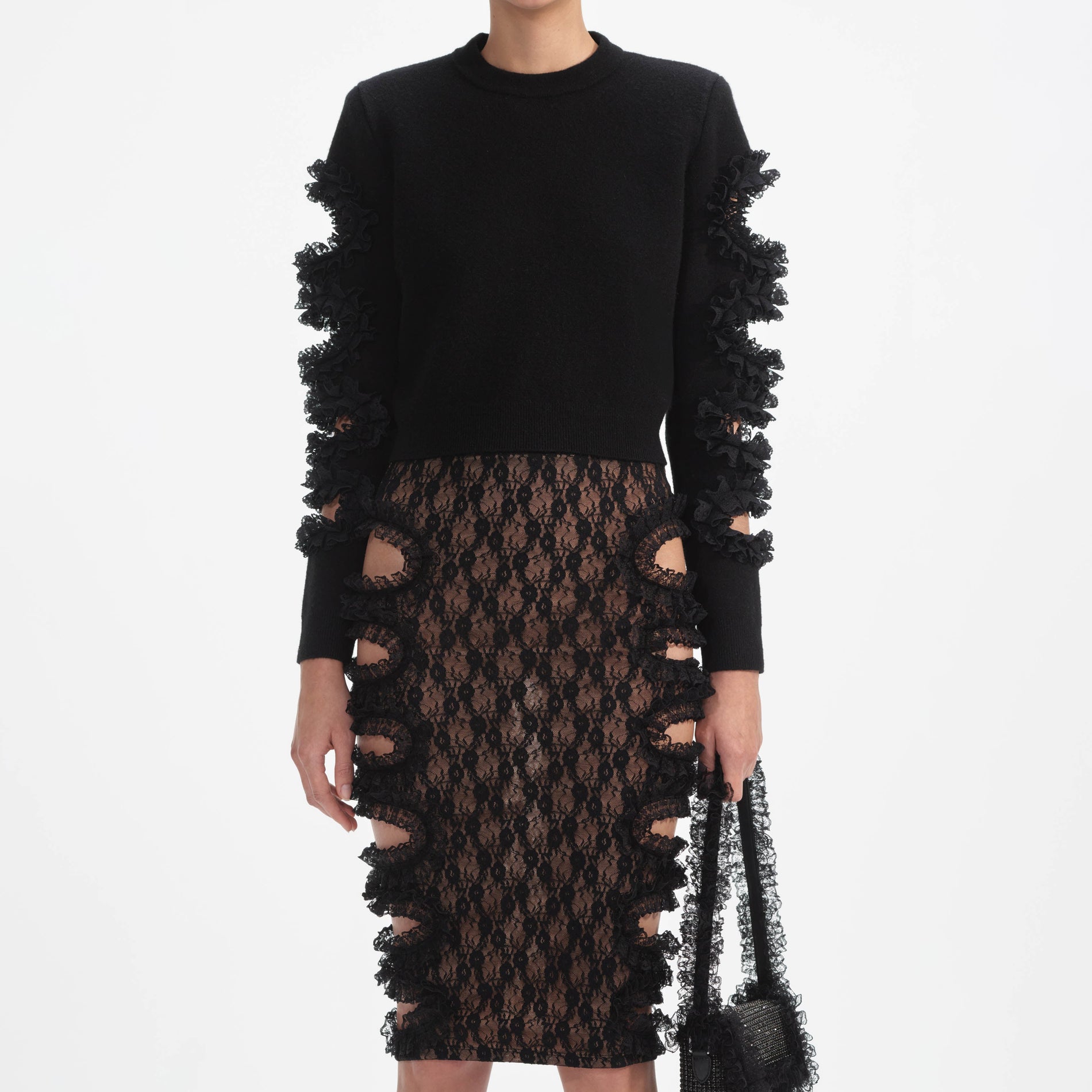 A close up of a woman wearing the Black Lace Cut Out Midi Skirt