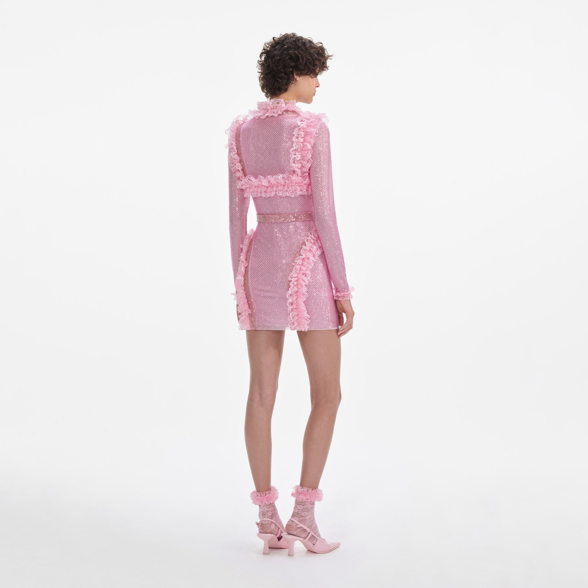 Back view of a woman wearing the Pink Rhinestone Mesh Ruffle Mini Dress