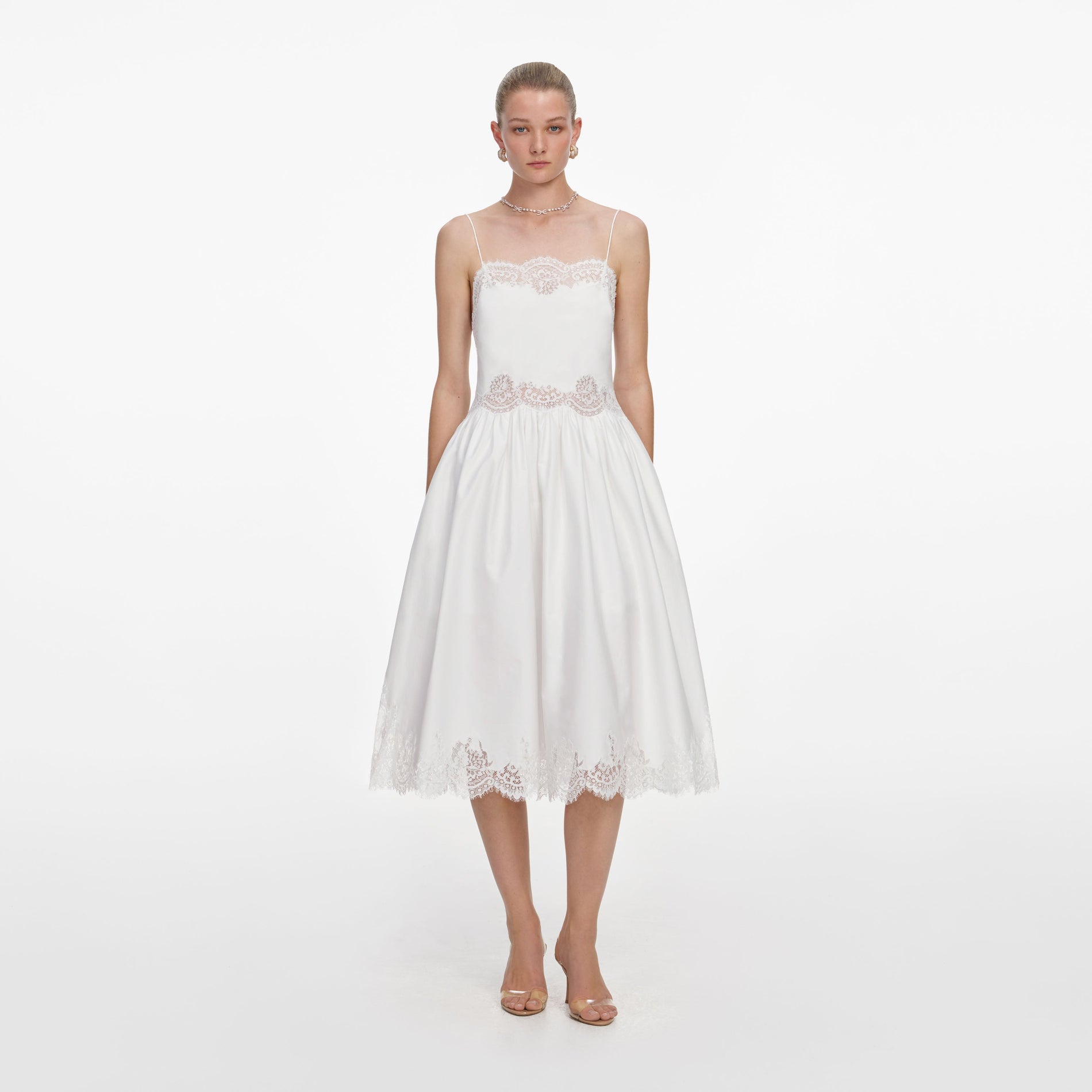 Front view of a woman wearing the White Cotton Lace Trim Midi Dress