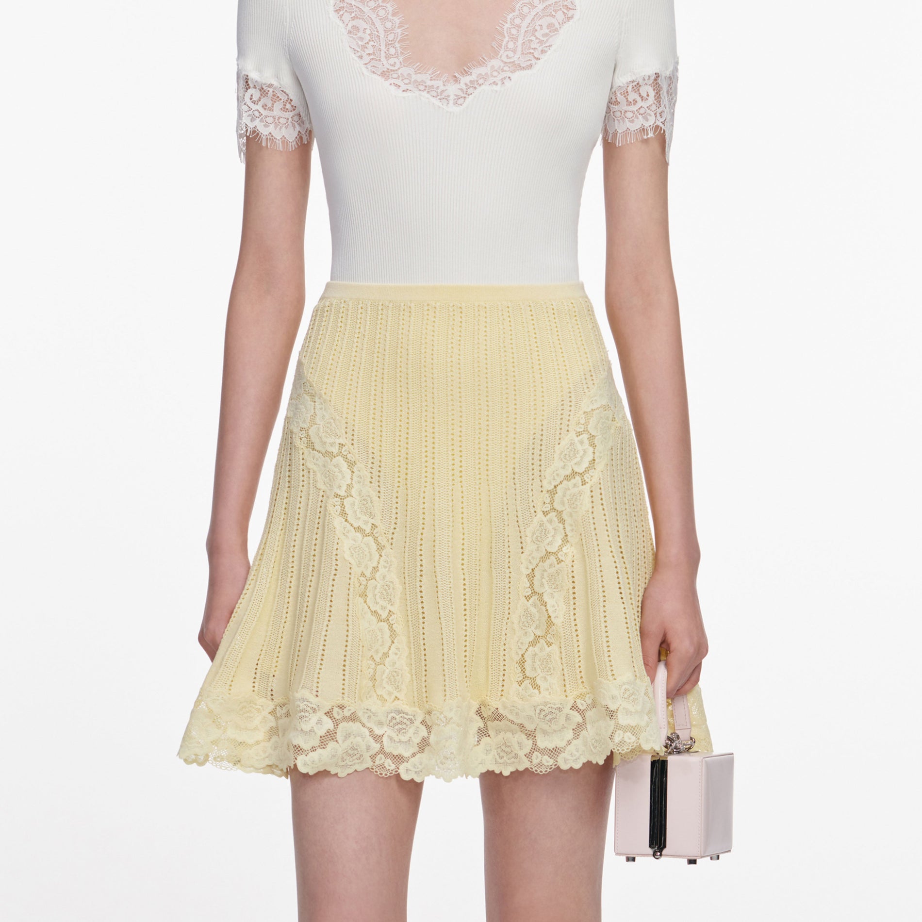 A close up of a woman wearing the Yellow Pointelle Knit Mini Skirt