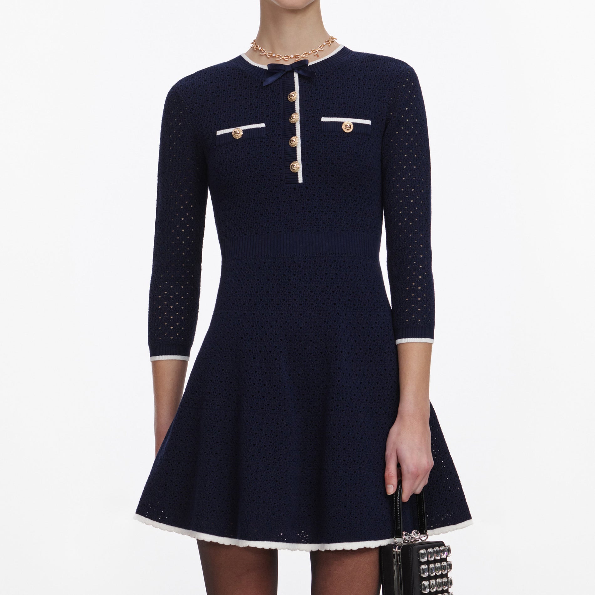 A close up of a woman wearing the Navy Bow Knit Mini Dress