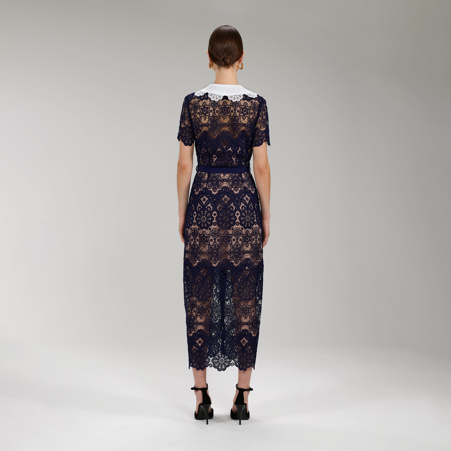 A woman wearing the Navy Floral Guipure Midi Dress