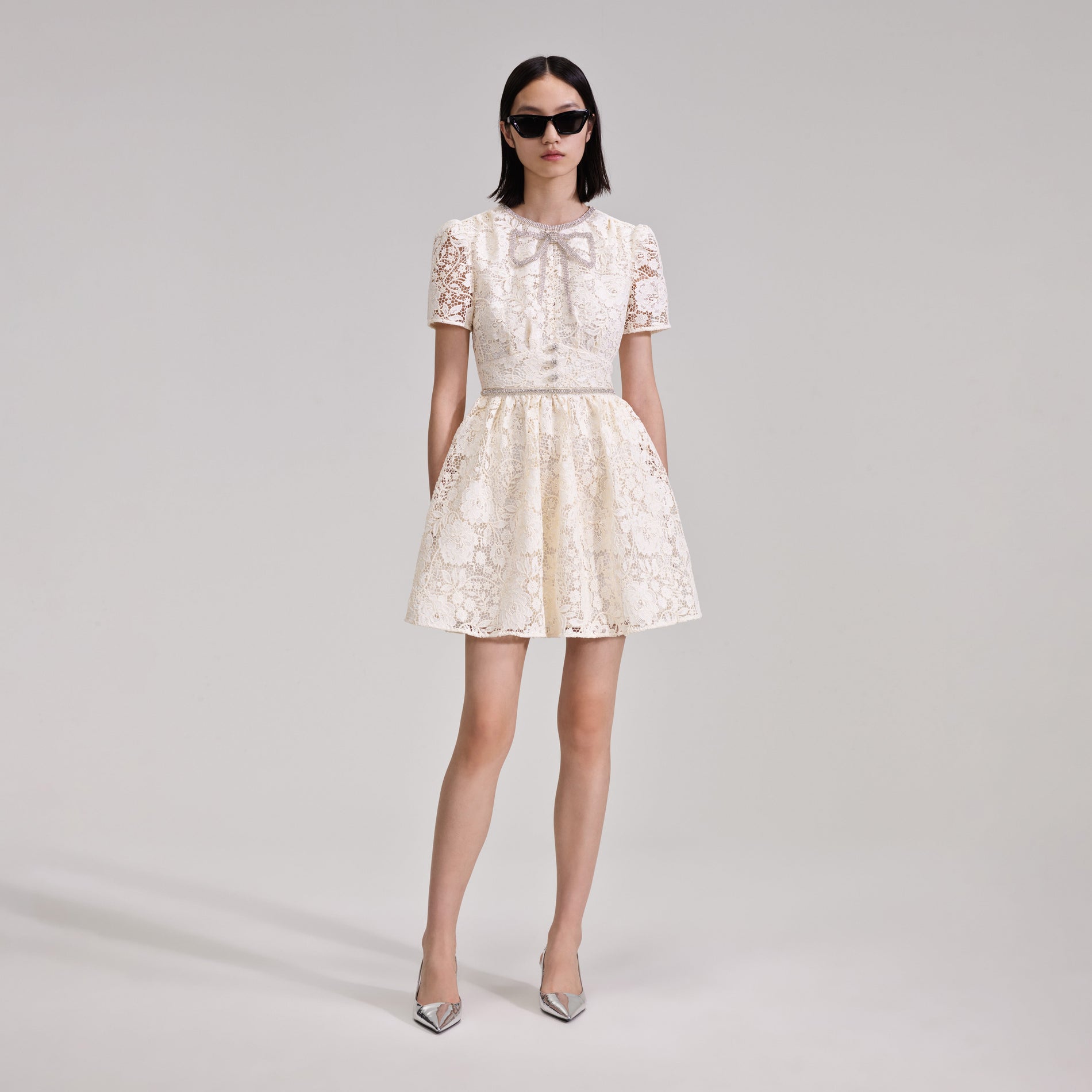 A woman wearing the Cream Cord Lace Bow Mini Dress