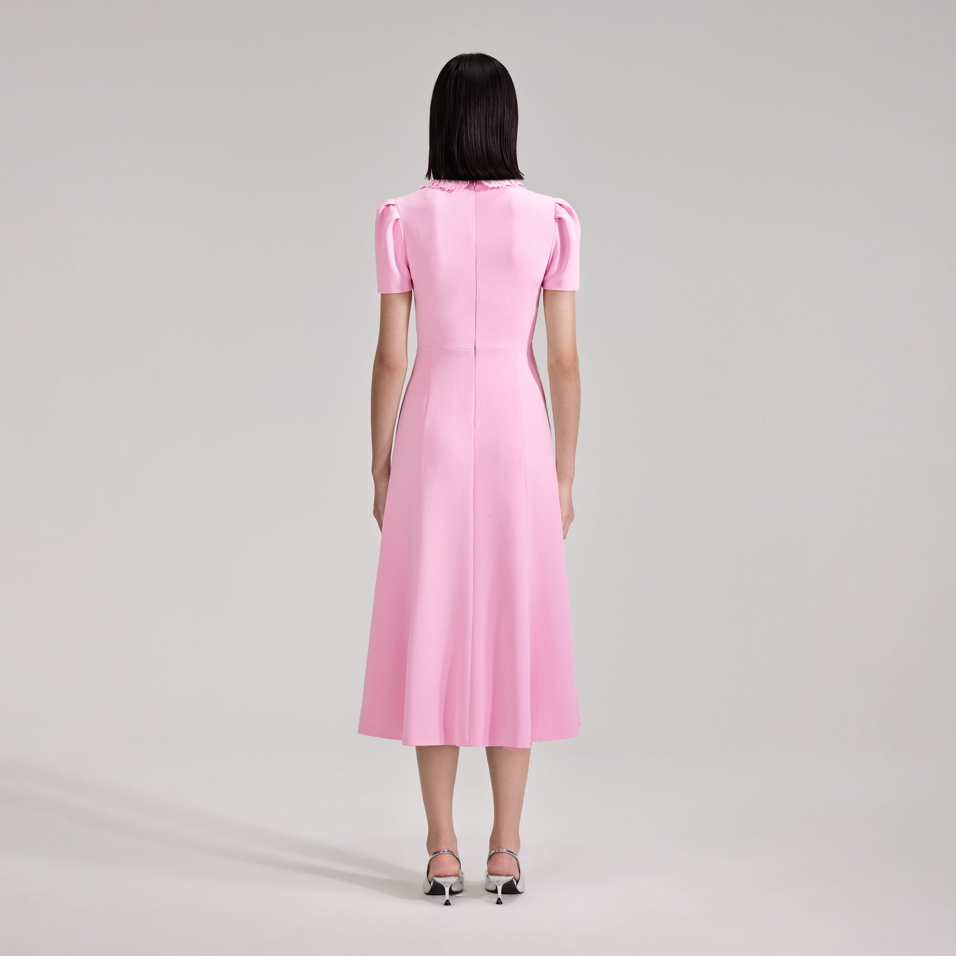 A woman wearing the Pink Heavy Crepe Midi Dress