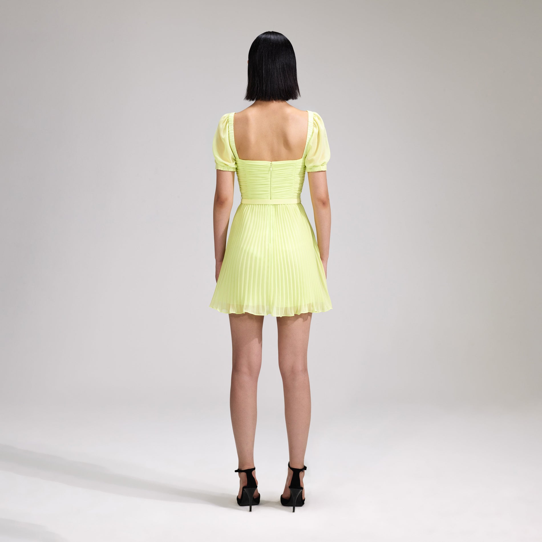 A woman wearing the Lime Chiffon Mini Dress