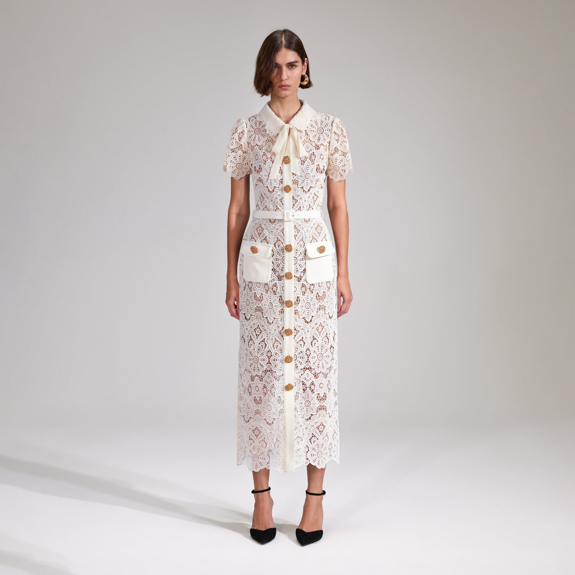 A woman wearing the Cream Floral Guipure Midi Dress