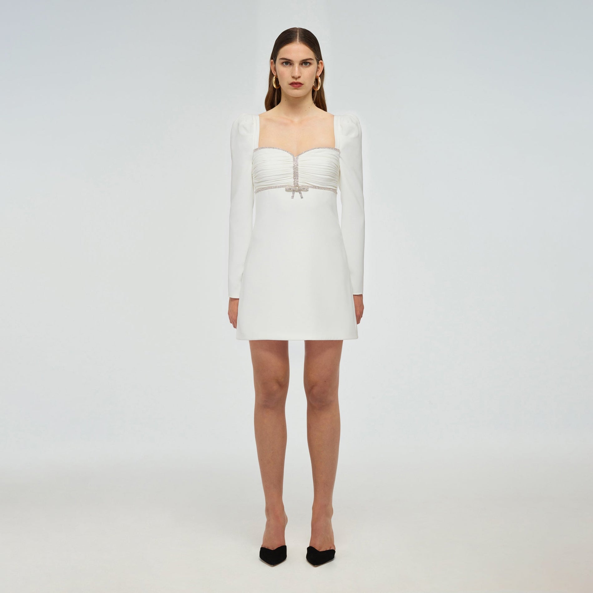 A woman wearing the White Crepe Diamante Mini Dress