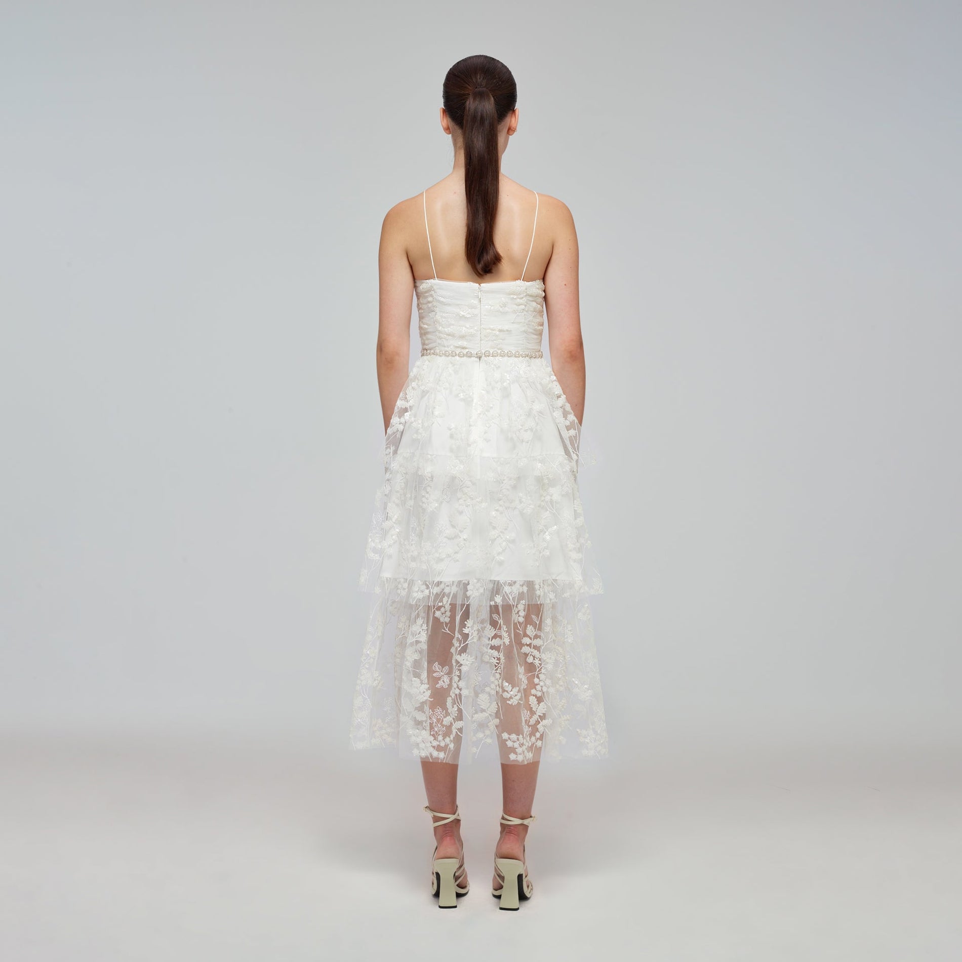 A woman wearing the Ivory Blossom Sequin Tiered Midi Dress